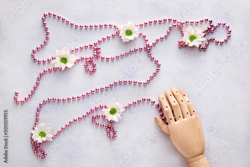 Wooden hand with pink beads...
