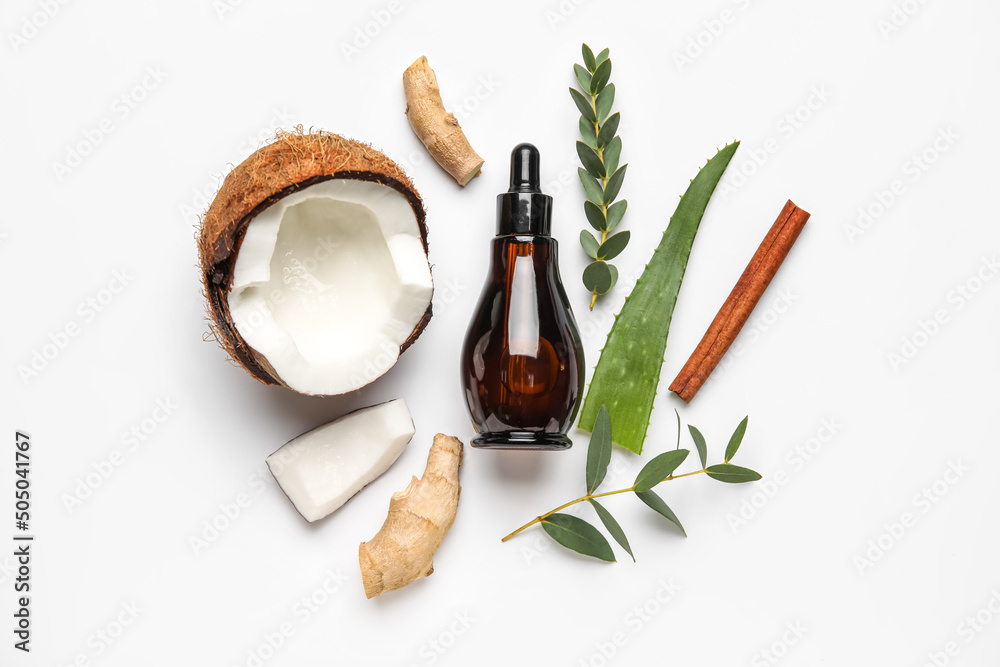 Bottle of natural serum with coconut, ginger, plant leaves and cinnamon on white background Bottle of natural serum with coconut, ginger, plant leaves and cinnamon on white background