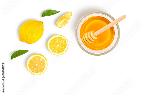 Glass bowl of pure honey with honey dipper and lemon slice isolated on white background. Top view