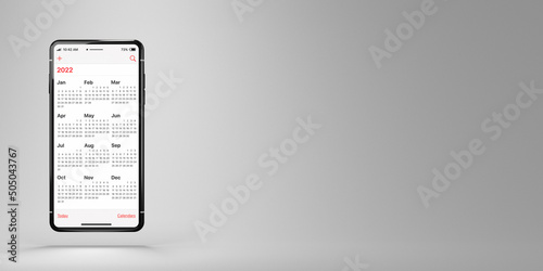 Black smartphone with Calendar 2022 app on white background and copy space. Calendar on the screen of a cell phone. The week starts on Sunday. Business or time management concept