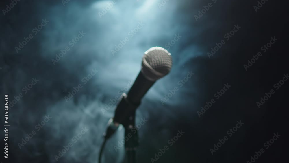 Microphone close-up, mic with smoke and black background. Karaoke singing, nightlife club or bar. Music, musical concert.