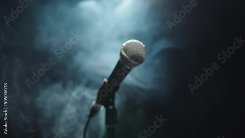 Microphone close-up, mic with smoke and black background. Karaoke singing, nightlife club or bar. Music, musical concert. photo