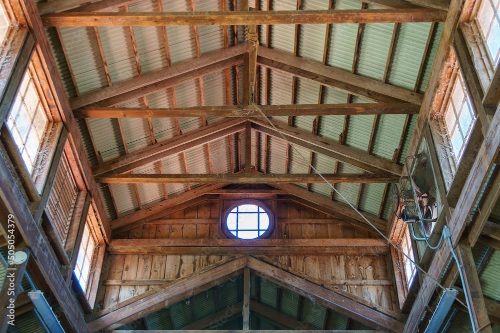 Barn ceiling with crossbeams and corrugated metal roof, circular window. Barn ceiling with crossbeams and corrugated metal roof, circular window.