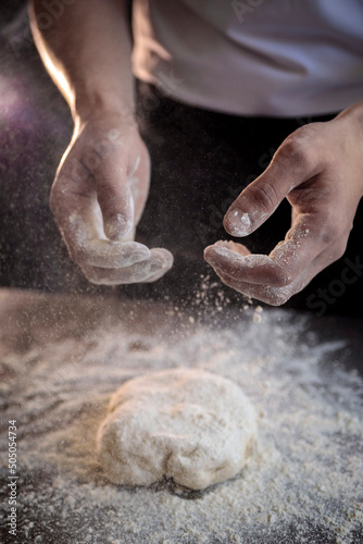 hands of the cook kneading pizza dough close-up