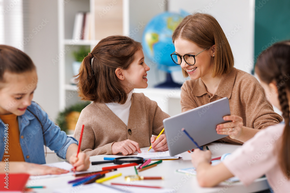 Woman with tablet teaching children at school Woman with tablet teaching children at school