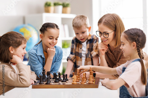 Woman teaching kids to play chess