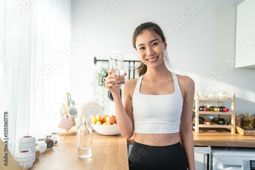 Portrait of Asian woman drink water after exercise and look at camera.