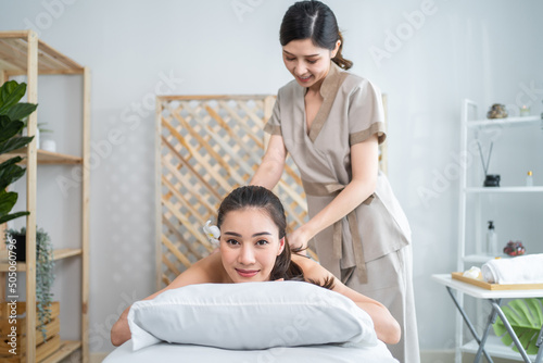Asian beautiful woman enjoy thai hot compress massage with herbal bags
