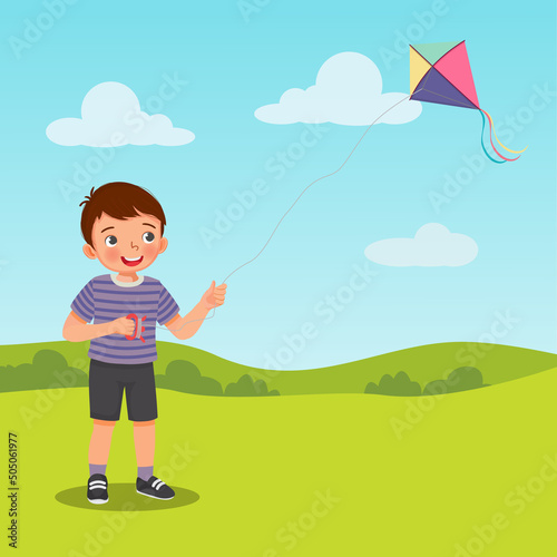 Little boy playing kite in the park on summertime