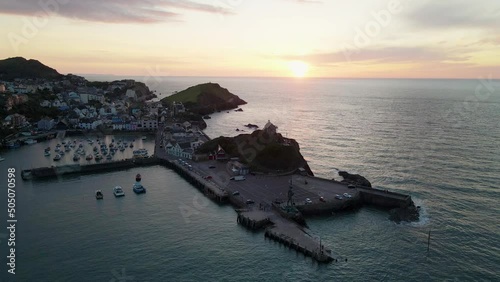 Sun Setting Over The Calm Sea At Sunset From Ilfracombe Harbour In Ilfracombe, England. - aerial photo