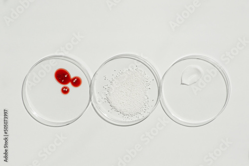Cosmetic swatches. Appearance of the texture of the cream, red mask and granules in petri dishes on a white background. Natural skincare products. Beauty concept for face and body care