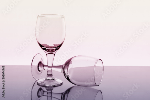 Two empty wine glasses with reflection on background, toned