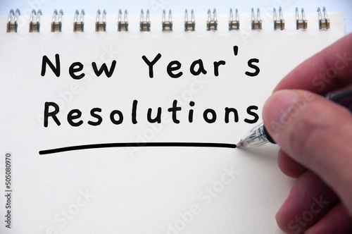Hand writing new year's resolution text on notepad.