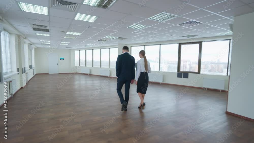 Business meeting, couple of top managers goes to a meeting, the interior of a white office space with panoramic windows, a walk through the office inside a skyscraper. Business meeting, couple of top managers goes to a meeting, the interior of a white office space with panoramic windows, a walk through the office inside a skyscraper.