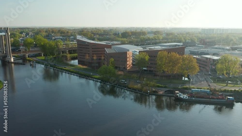 Pristine Riverbank And Contemporary Business Center Of Zuidelijk Halfrond Province With View Of Train Bridge In Gouda, Netherlands. Wide Aerial photo