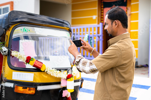 Photography Driver busy taking picture of his new auto Rickshaw before driving to post on so
