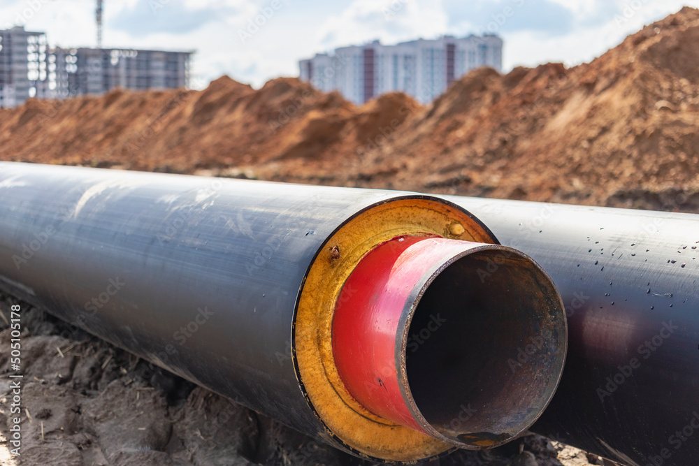 Insulated pipe. Large metal pipes with a plastic sheath at a construction site. Modern pipeline for supplying hot water and heating to a residential area. Insulated pipe. Large metal pipes with a plastic sheath at a construction site. Modern pipeline for supplying hot water and heating to a residential area.