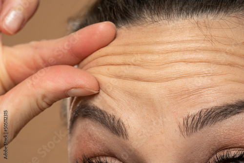 Woman checking her wrinkles on her forehead