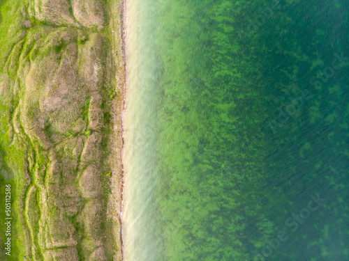 Aerial view of beautiful surrealistic terrain with hills near calm green water river estuary in Ukraine