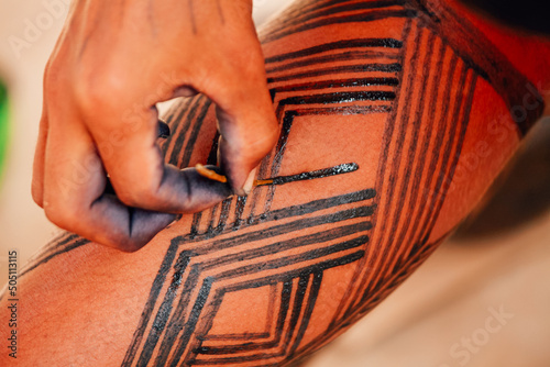 Indian painting leg with the geometrical art of the Asurini indigenous tribe in the Brazilian Amazon.  photo