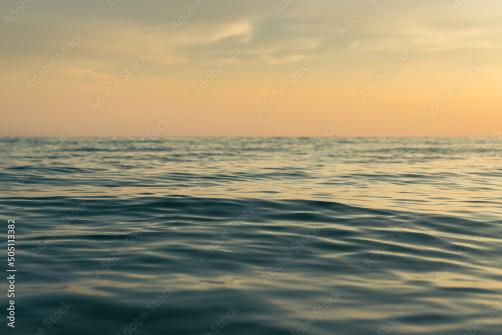 Obraz premium amazing shot of a calm blue sea on orange sunset background. Landscape Seascape, Amazing beach scene vacation and summer holiday concept. Luxury travel. background and copy space. Sea travel holiday.