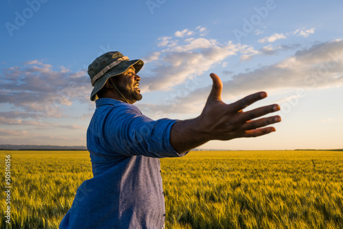 Fototapet Farmer is standing in his growing wheat field