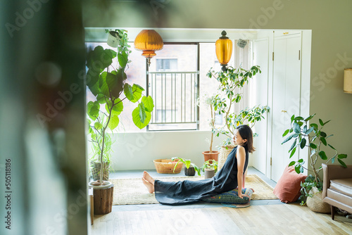 A woman relaxing surrounded by foliage plants Fototapeta