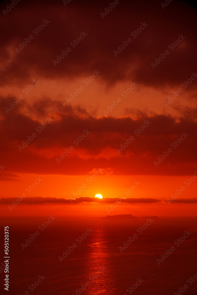 Red sun in the clouds. Great dramatic view. Meditative calmness and greatness. Colorful sunset in the evening sky. Clouds illuminated by the setting sun. Amazing sky panorama