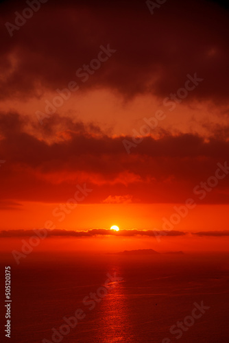 Red sun in the clouds. Great dramatic view. Meditative calmness and greatness. Colorful sunset in the evening sky. Clouds illuminated by the setting sun. Amazing sky panorama © watman