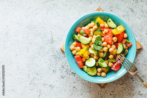 Chickpea salad with tomatoes, cucumber, parsley, onions in a plate, selective focus. Healthy vegetarian food, oriental and Mediterranean cuisine. Chick peas salad