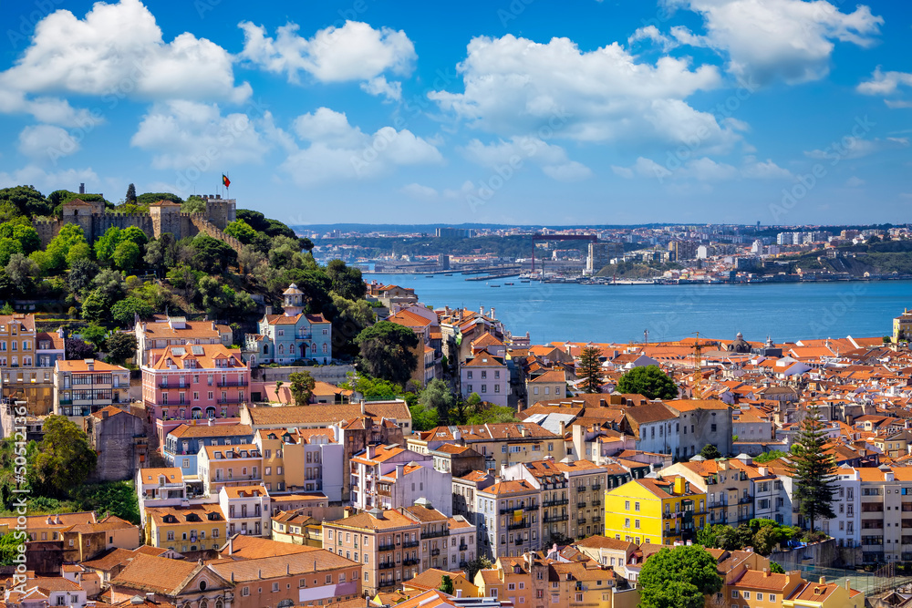 The cityscape of Lisbon, Portugal, with Sao Jorge Castle and the red roofes of the Alfama district on a sunny day