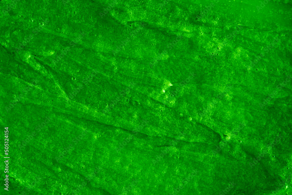 Fototapeta premium Smears of liquid green gel texture background. Smeared oil paint with pearly shine. Cream scrub to cleanse the skin of the face and body. Spa treatments, skin care.