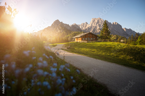 Idyllic alpine hut in front of a beautiful mountain backdrop.