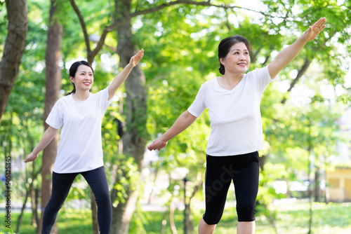 Image of Asian mother and daughter exercise at park