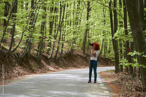 Travel photographer lady shooting in a forest