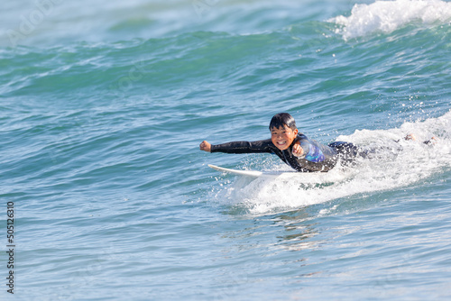 湘南の海でサーフィンをする少年