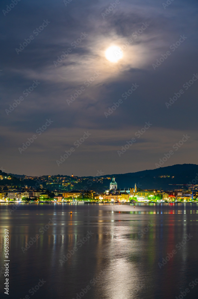 The city of Como, photographed in the evening, with the lakefront, the cathedral, and the surrounding mountains.

