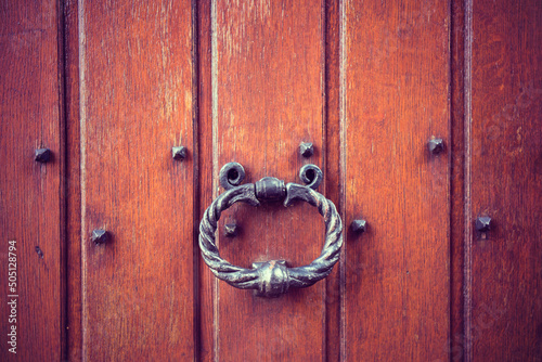 Antique, old style, iron door handle on a wooden door. 