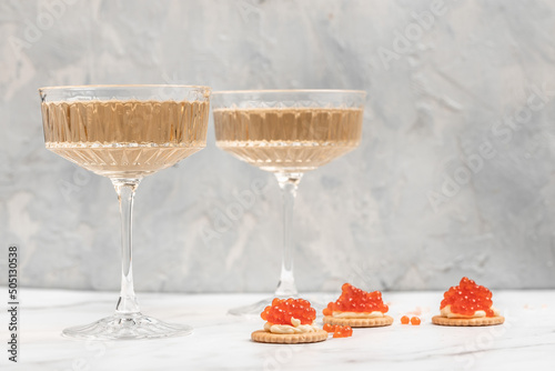 Delicious snacks with cream cheese and red caviar with glass of champagne, Festive drink. Valentins or Christmas concept