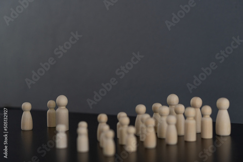 wooden mannequin on wooden floor arranged in groups at the meeting Leadership concept wooden puppet man on black table gray background