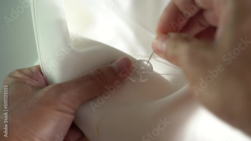 Hands sewing button