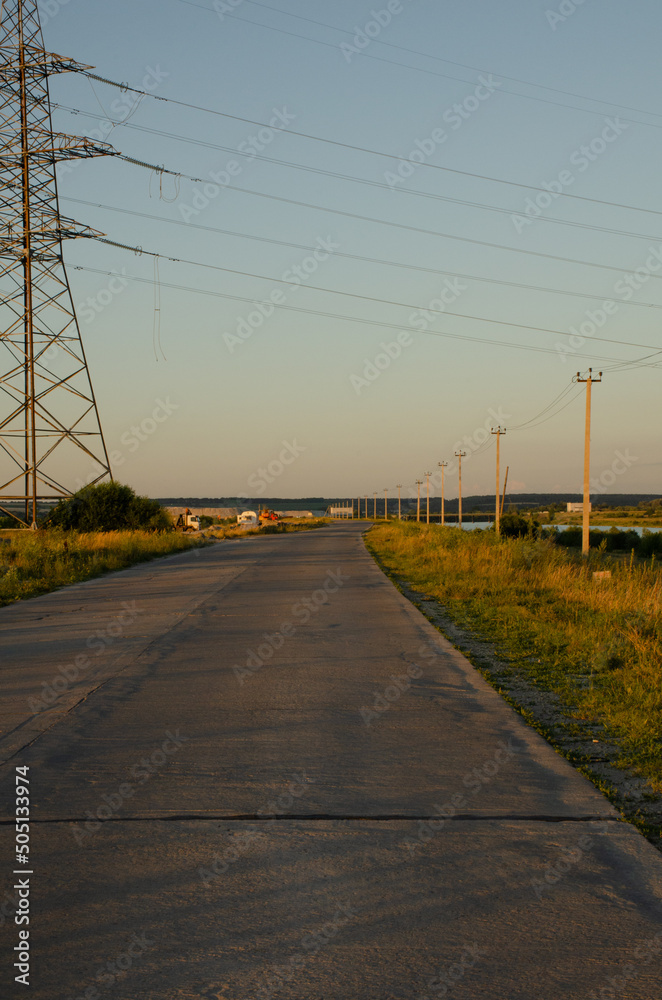 Asphalt road outside the city against the background of a blue sunset sky