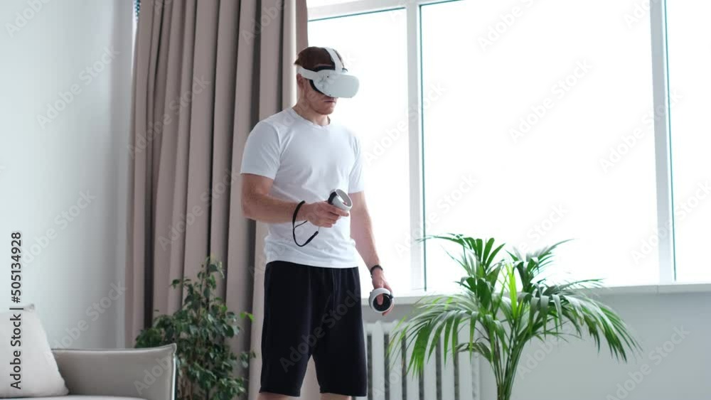 guy puts on his head a virtual reality helmet. Handsome man wearing future technology VR glasses. Young man using AR indoors. man wearing virtual reality device. guy puts on his head a virtual reality helmet. Handsome man wearing future technology VR glasses. Young man using AR indoors. man wearing virtual reality device.