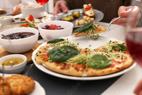 Man taking slice of pizza during brunch at table, closeup