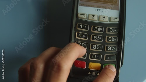 Closeup shot of customer pay over the wireless tradings card-reader. Adult human hands of businessman use bankcard: leans, entering password to withdraw funds then hold and sliding. Noncash payments photo