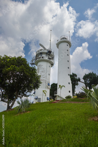 Bukit Jugra, Malaysia - April 16,2022: The lighthouse with the civilian radar system on the roof at the famous hiking and tourist spot on top of the Jugra hill, at the shore of the street of Malaka photo