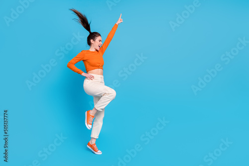 Full size profile side photo of good mood energetic funky girl dancing have fun isolated on blue color background
