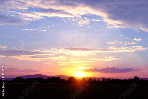 sunset in evening beautiful dramatic sky with cloud, background light sky gradient, concept of heavenly space, abode of God, meditative calmness and greatness, black silhouette of hills at bottom © kittyfly