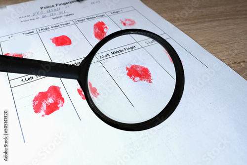 Photos magnifying glass, fingerprints with in police fingerprint card, concept of arres