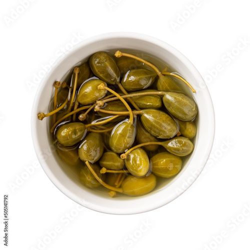 Pickled caper berries in a white bowl isolated on white background. Marinated fruits of caper bush. Canned caperberry as condiment and garnish. Common ingredient of mediterranean cuisine.